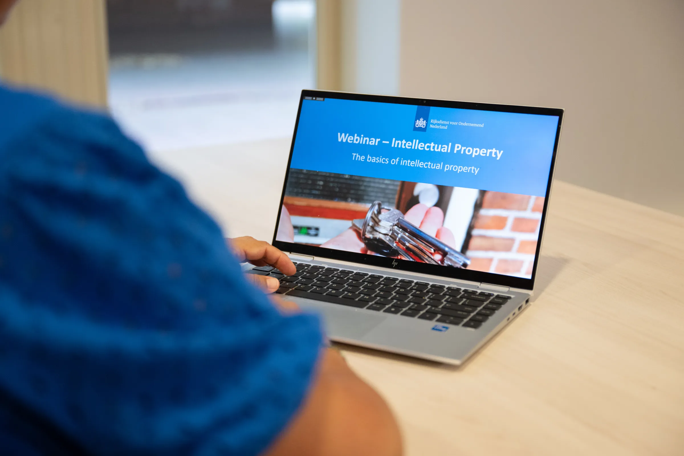 Persoon kijkt naar webinar op laptop